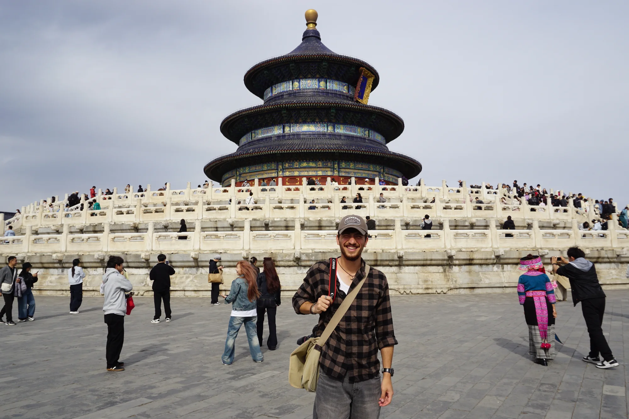 Yonatan Vilan smiling in front of the Temple of Heaven in Beijing, camera strap over his shoulder